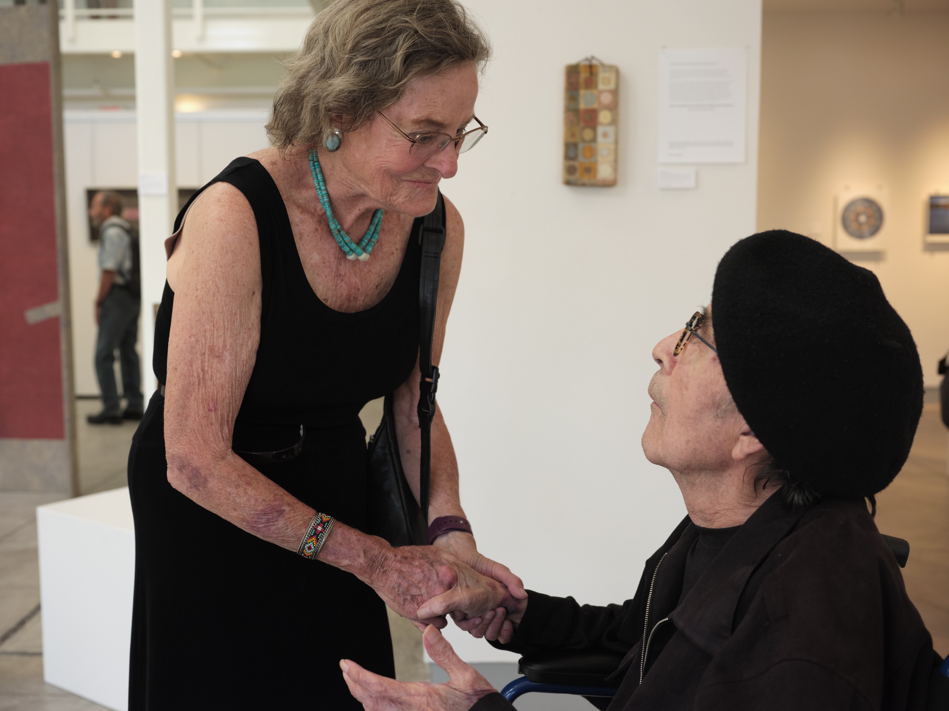 Two elderly people shaking hands