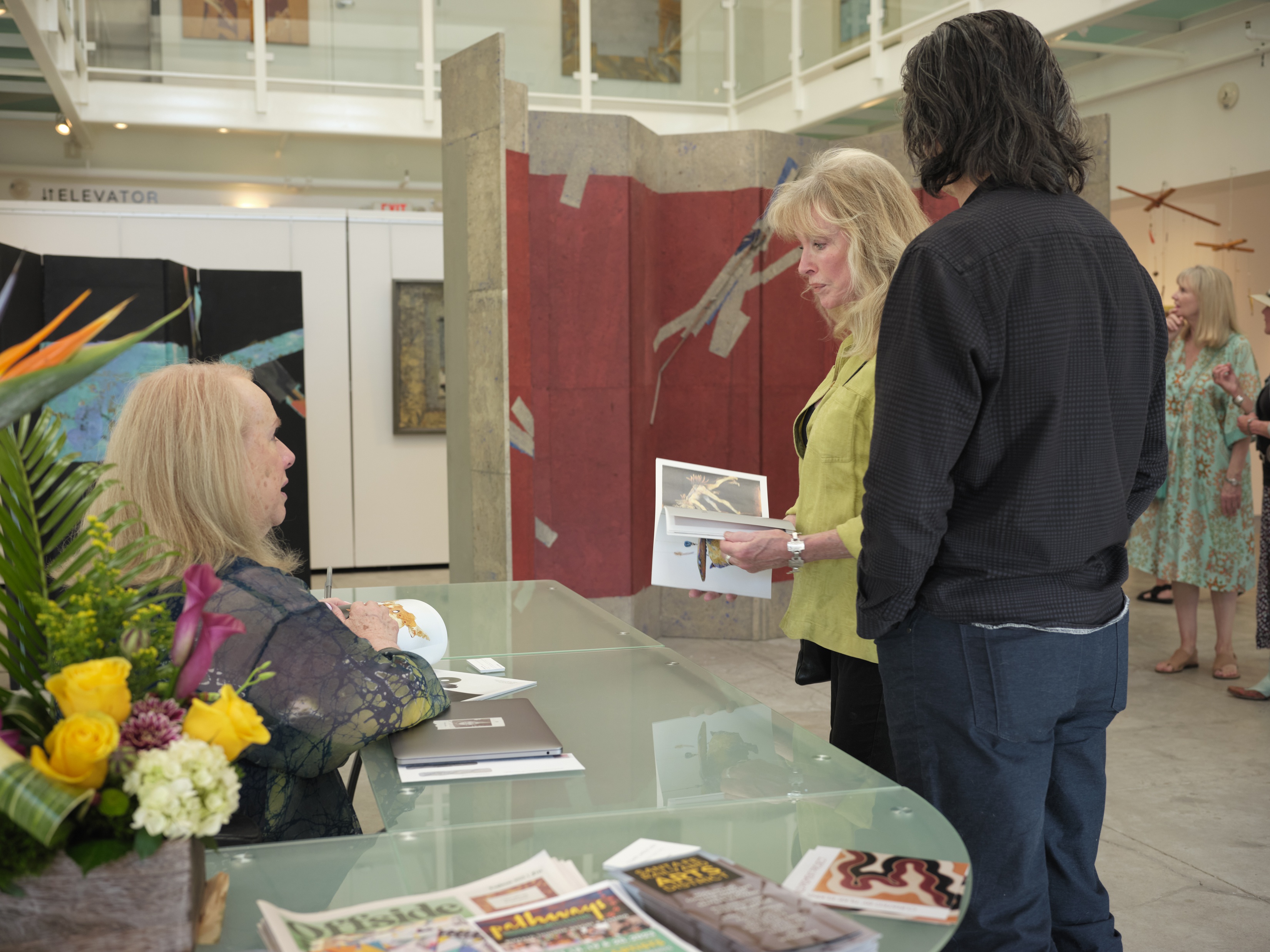 Woman behind desk talking to guests