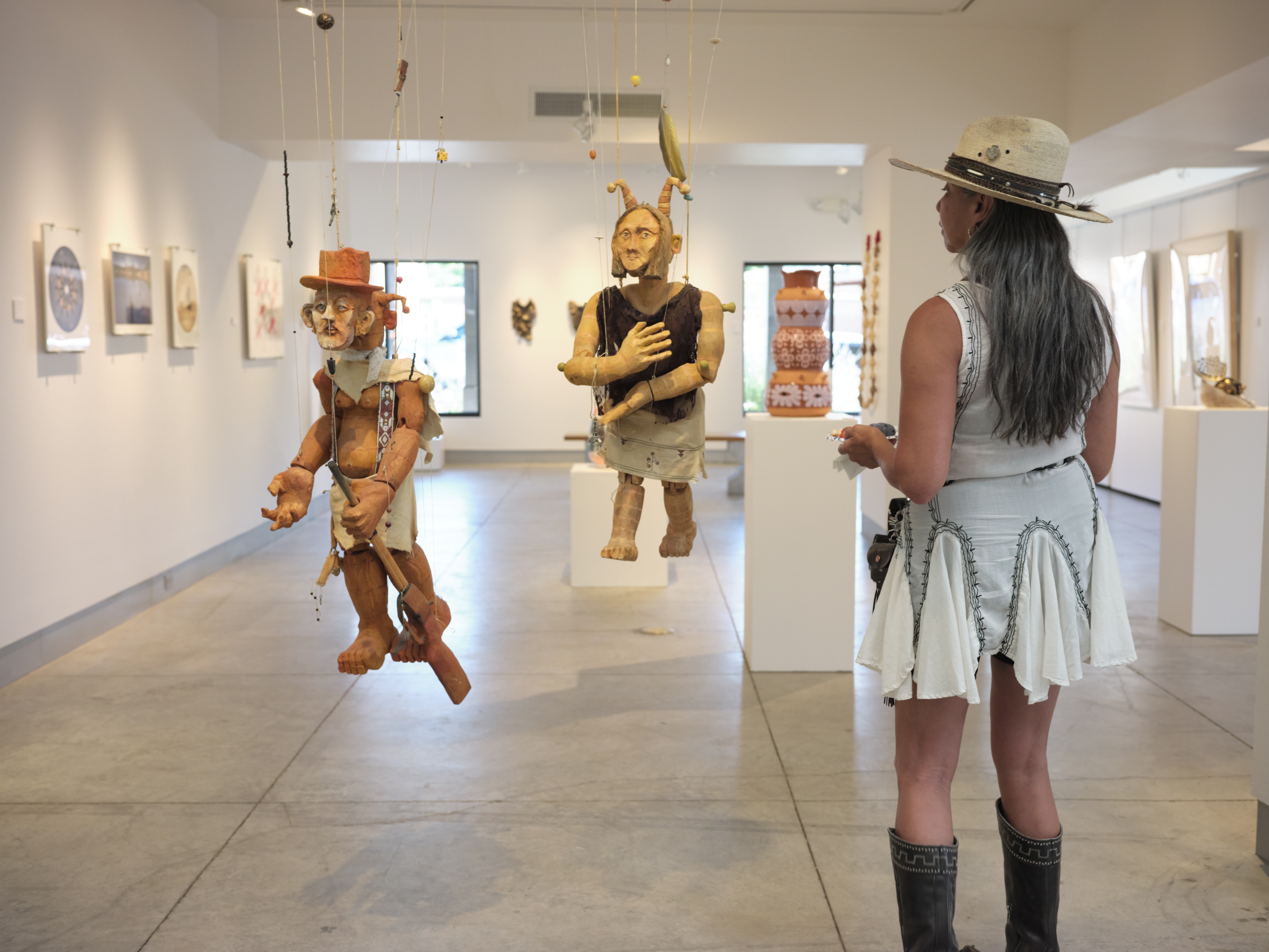 Woman examines marionettes