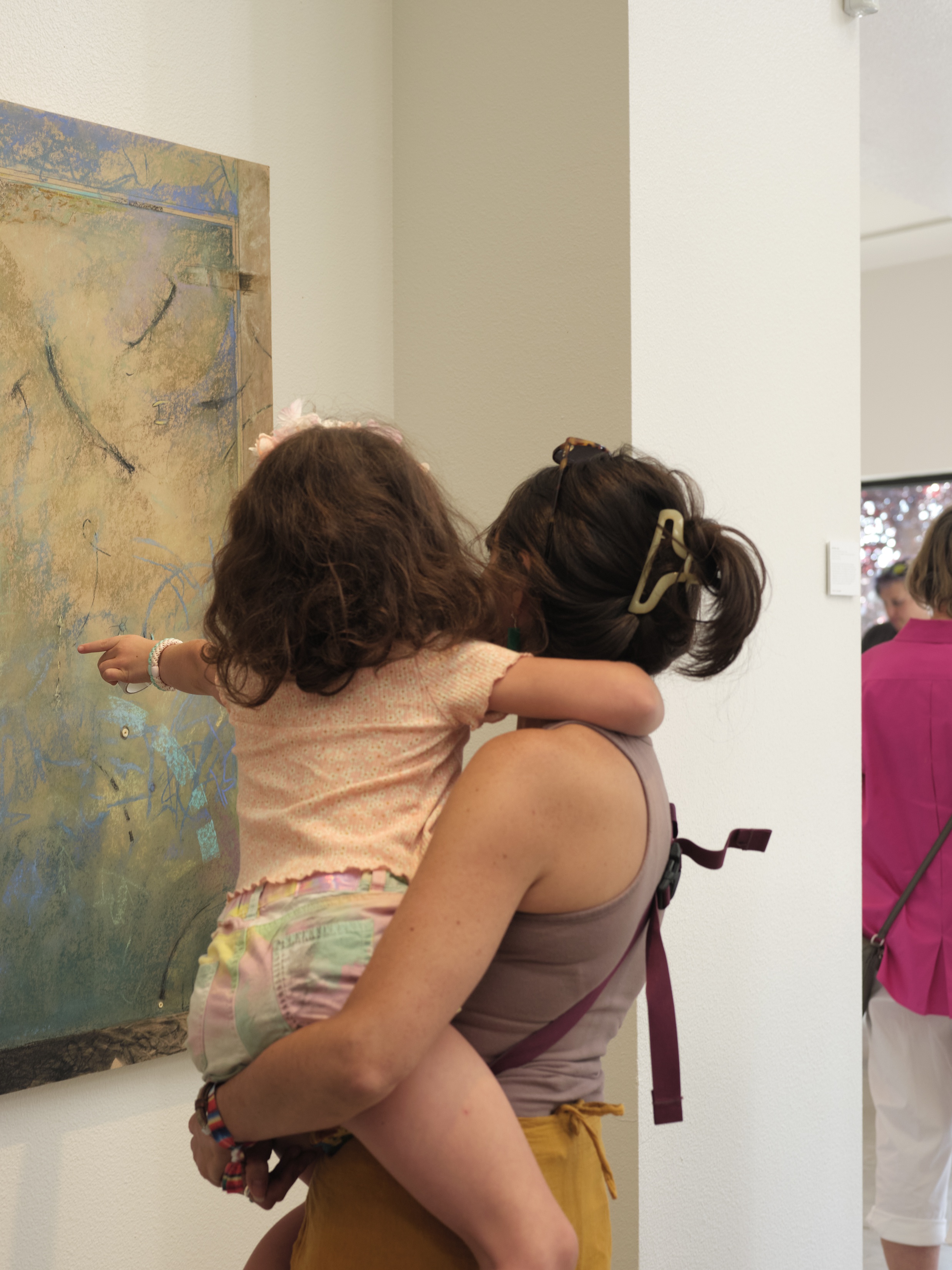 A little girl points at a large pastel