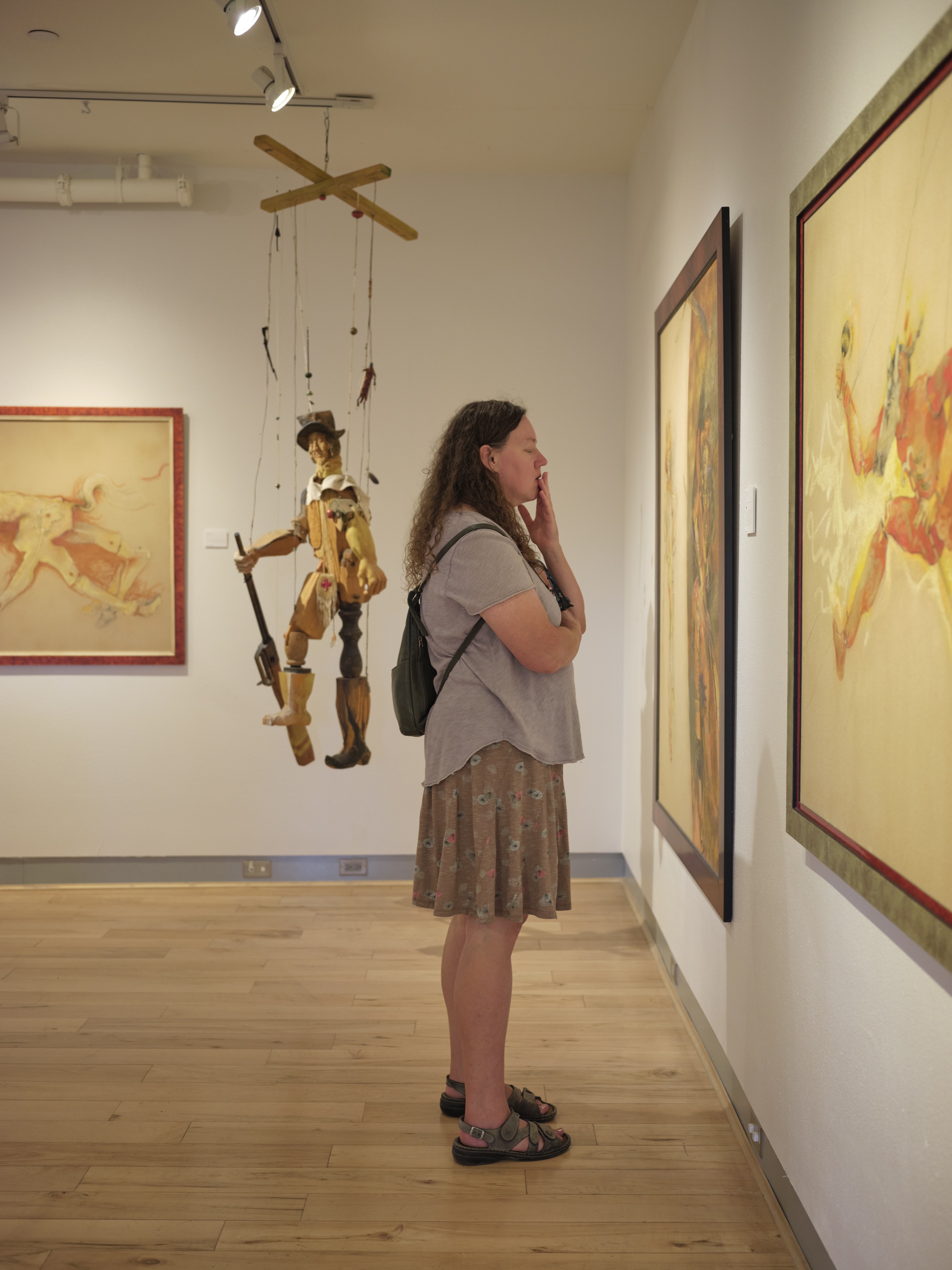 woman with eyes closed in front of artwork