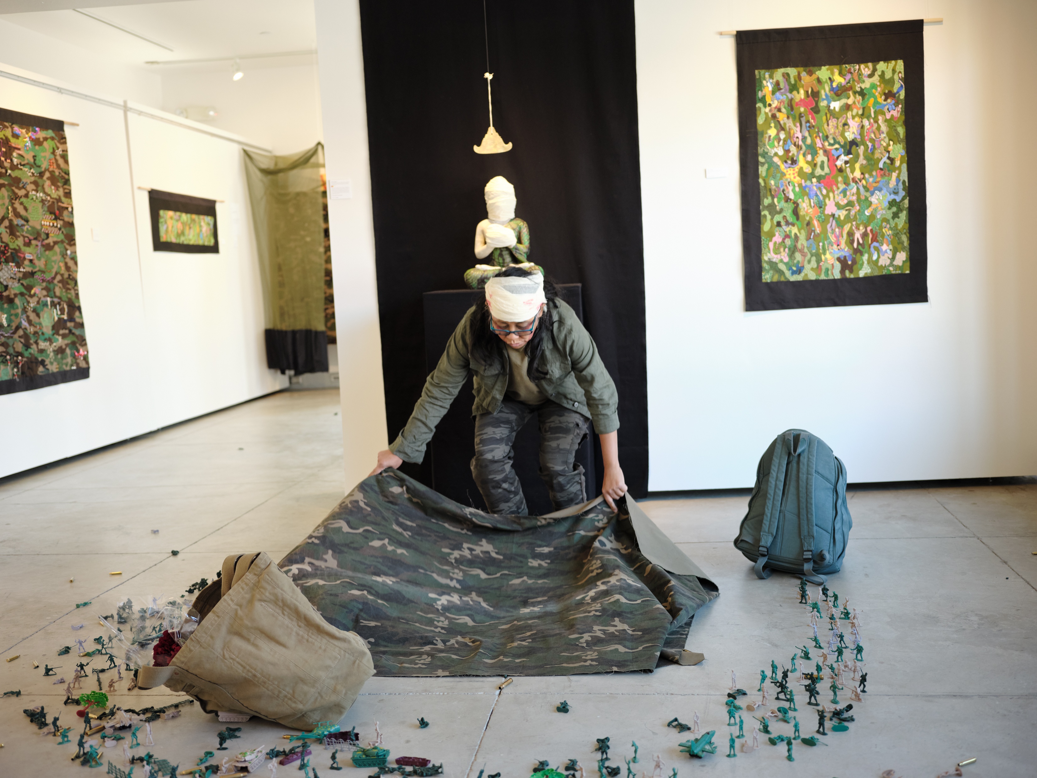 Artist lays out camouflage tarp